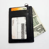 Pebbled Leather Card Case in black - front side with one card inserted, ID inserted in ID section, and money inserted into