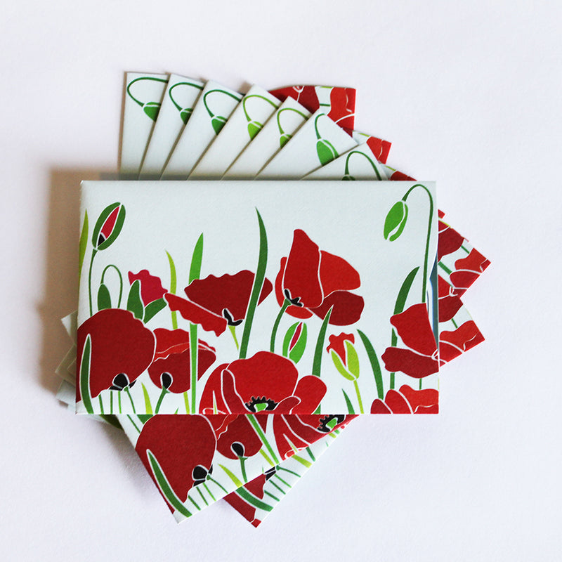 A stack of Rogue Industries RFID Blocking Package of Credit Card Sleeves with red poppies on them, designed for RFID blocking against skimming attacks.