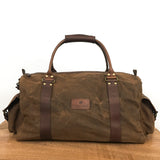A water-resistant, brown Rogue Industries White Cap Waxed Canvas Duffle on a wooden table.