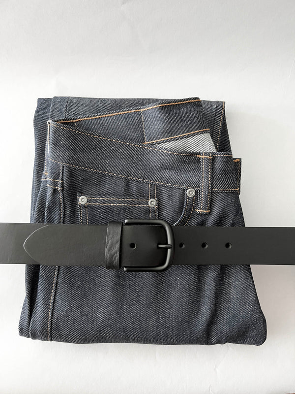 A pair of jeans with a black, handmade Rogue Industries Baxter Leather Belt - 1.5" Wide.