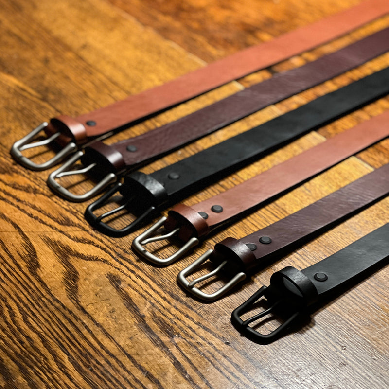 Five Rogue Industries Baxter Leather Belts - 1.5" Wide are lined up on a wooden table.