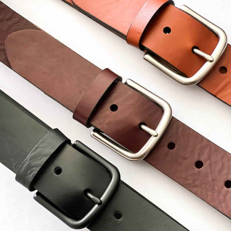 Four different colors of Chamberlain Leather Belts - 1.25" Wide by Rogue Industries on a white surface.