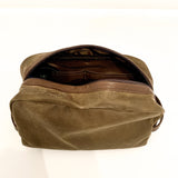 A durable, Rogue Industries Waxed Canvas Dopp Kit on a white surface, Made in USA.