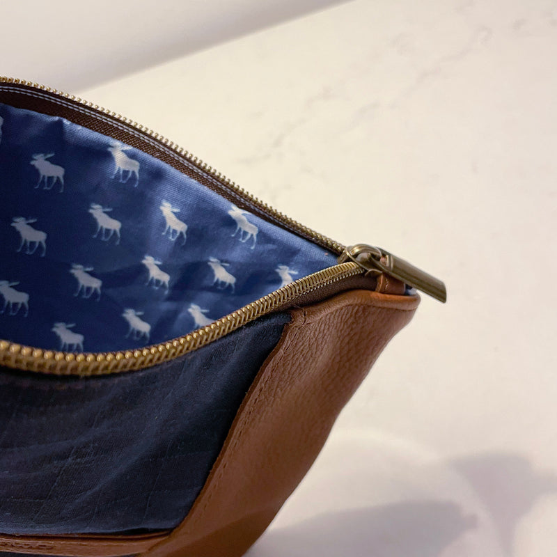 A blue and white leather pouch with a deer on it.
Product Name: Eastport Clutch
Brand Name: Rogue Industries

A Rogue Industries Eastport Clutch with a deer on it.