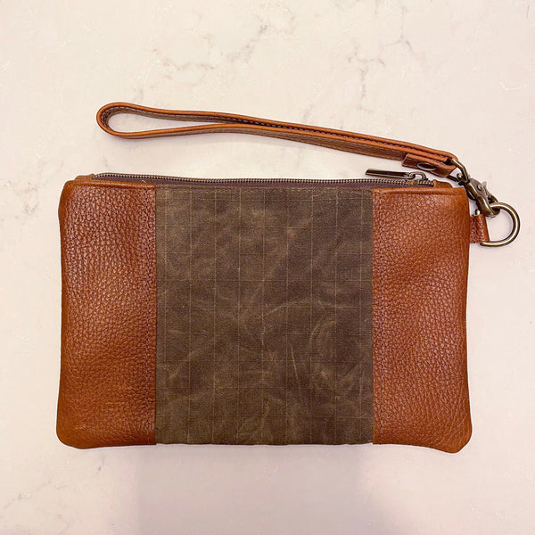 A brown and tan leather Eastport Clutch by Rogue Industries with a zipper.