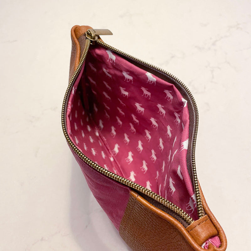 The inside of a pink and tan waxed canvas Eastport Clutch cosmetic bag by Rogue Industries.