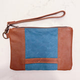 A blue and tan waxed canvas and leather Eastport Clutch wristlet by Rogue Industries.