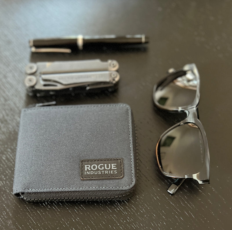 Rogue Industries Nylon Zip Around Wallet with sunglasses and a pen on a table, featuring an RFID blocking mechanism.