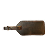 A brown Rogue Industries cowhide leather luggage tag made in Maine on a white background.