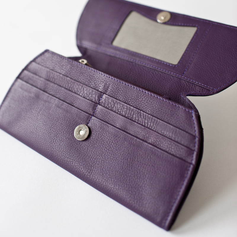 A purple leather RFID Blocking Clutch with a mirror and ostrich print from Rogue Industries.