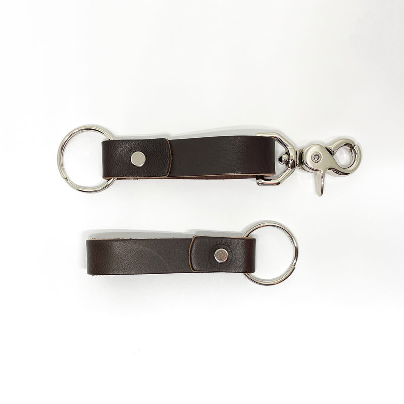 Two durable Rogue Industries brown leather keychains on a white background.