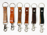 A row of different colored, durable Rogue Industries leather keychains on a white background.