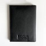 A black Rogue Industries Leather Passport Holder for travelers on a white surface.