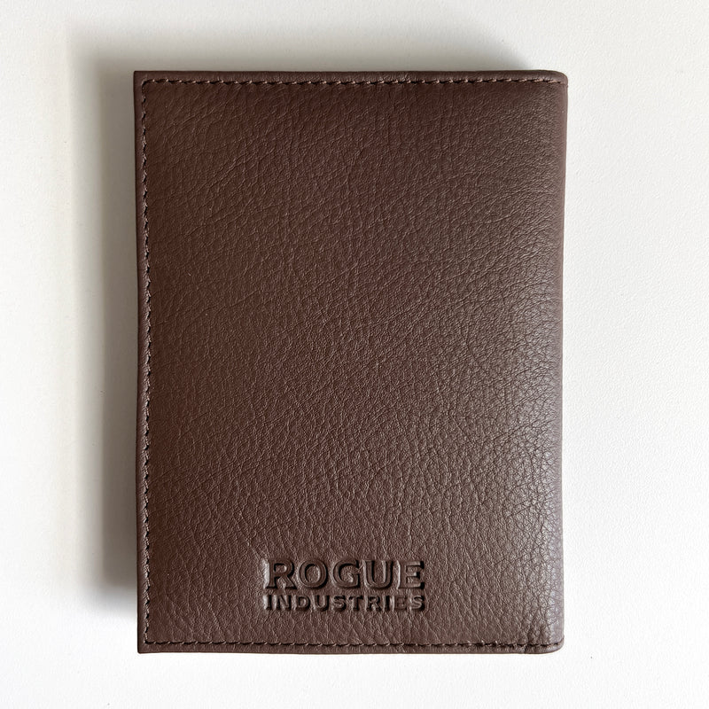A Rogue Industries brown leather passport holder with the word "focus" monogrammed on it.