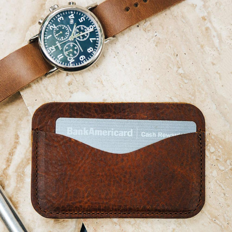 A Maine-crafted leather wallet with a watch and a Rogue Industries American Bison leather card case.