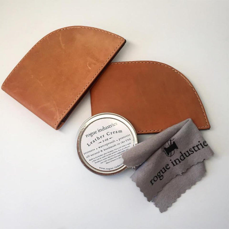 A tan leather wallet with a tin can of Rogue Industries All Natural Leather Cream and a cloth.