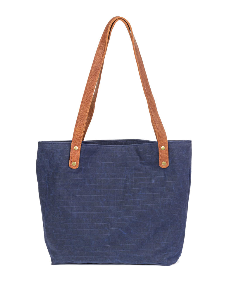 A durable, blue waxed canvas Allagash River Tote Bag with tan handles, crafted in Maine by Rogue Industries.