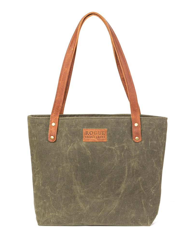 A durable, green waxed canvas Allagash River tote bag with brown leather handles, made by Rogue Industries in Maine.