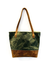A green and waxed canvas Saco River Tote Bag with tan leather accents by Rogue Industries.