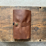 A top-grain leather Rogue Industries Leather Tech Organizer on top of a wooden box.