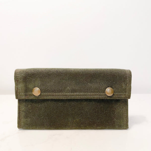 A green Rogue Industries waxed canvas bag with two buttons.