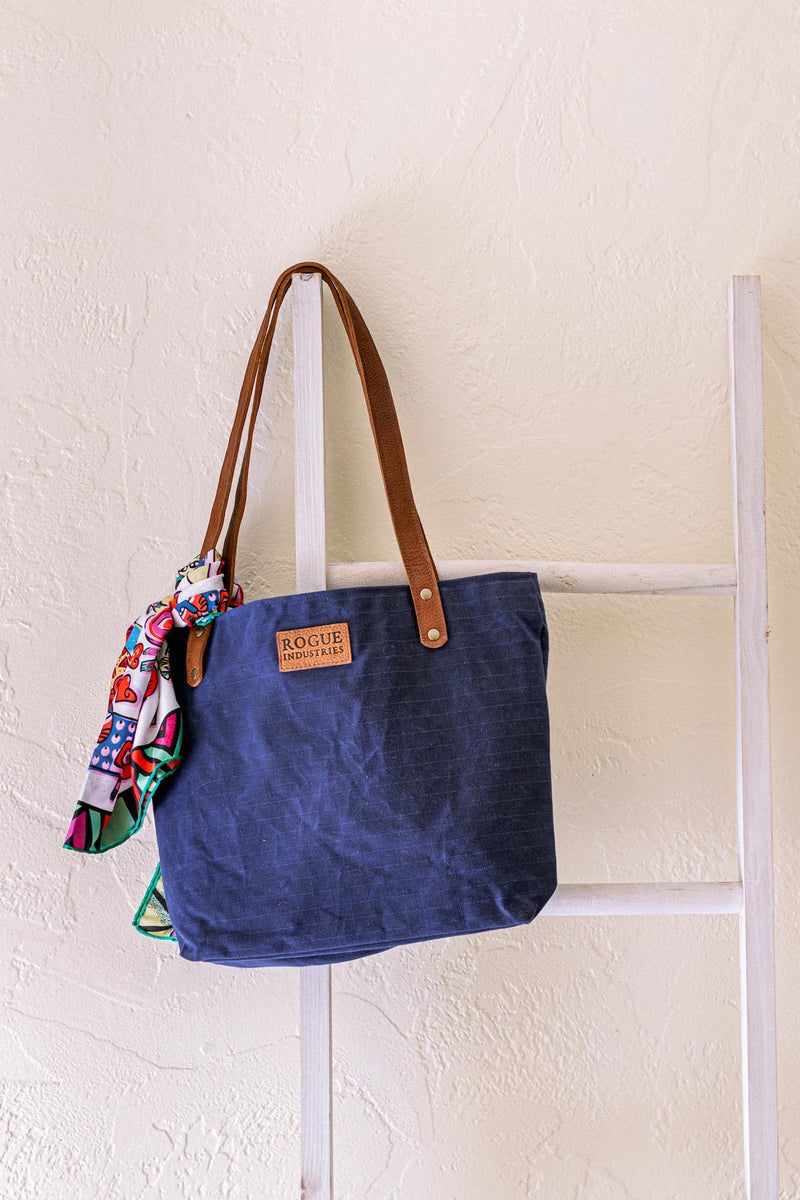 A durable Rogue Industries Allagash River Tote Bag hanging on a ladder.