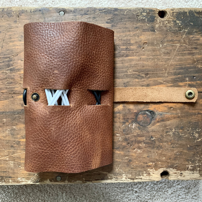 A Rogue Industries Leather Tech Organizer on a wood surface.