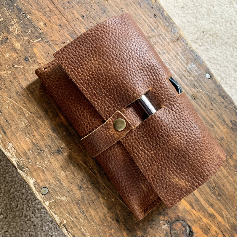 A brown Rogue Industries Leather Tech Organizer sitting on top of a wooden table.